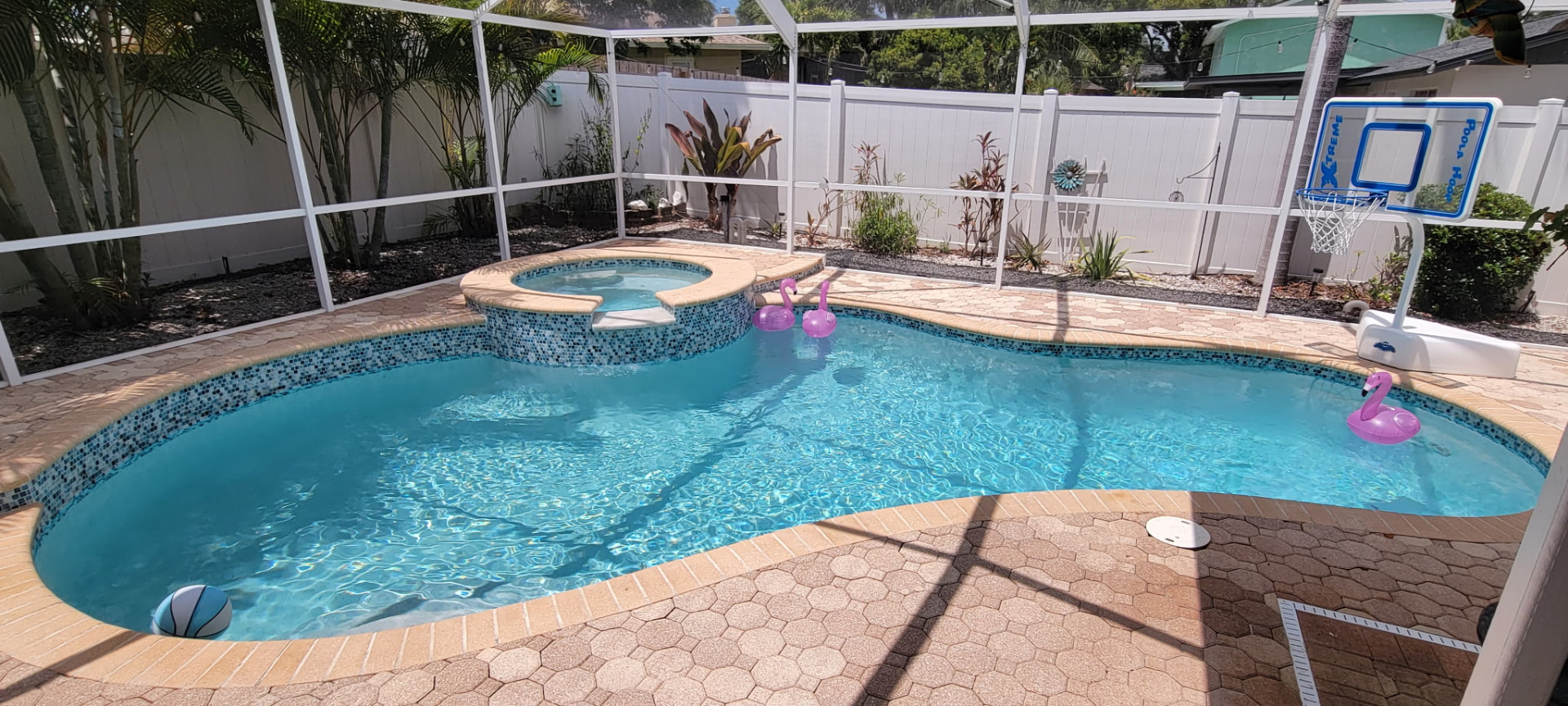 Free form pool and raised spa with mosaic tile and paver deck